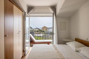 une chambre avec un lit et un balcon dans l'établissement Mediterano Apartments, à Podstrana