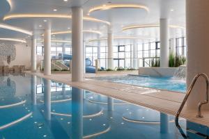 una piscina en un edificio con piscina en Baltini Premium Apartament Polanki Aqua en Kołobrzeg
