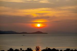 einen Sonnenuntergang über dem Wasser mit der Sonne am Himmel in der Unterkunft Sunset Estates - Samui Luxury Villas in Strand Choeng Mon