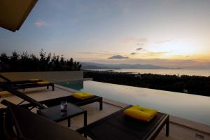a patio with a pool and a view of the ocean at Sunset Estates - Samui Luxury Villas in Choeng Mon Beach