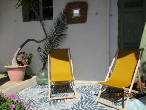 duas cadeiras amarelas sentadas em frente a uma casa em Face au Cap 1 em Cassis