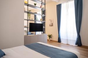 um quarto com uma cama e uma televisão numa prateleira em EVE Home Collection - City Center em Trieste