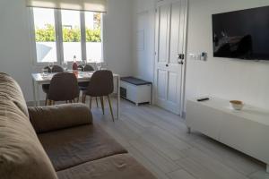 a living room with a couch and a table with chairs at Apartamento Villa Irene Menorca in Cala Santandria