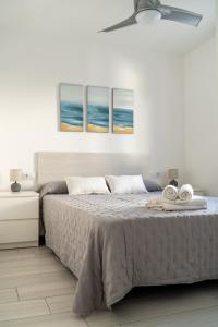 a bedroom with a large bed with two pictures on the wall at Apartamento Villa Irene Menorca in Cala Santandria