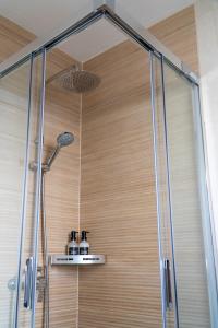a shower stall with a glass door and a shower at Apartamento Villa Irene Menorca in Cala Santandria