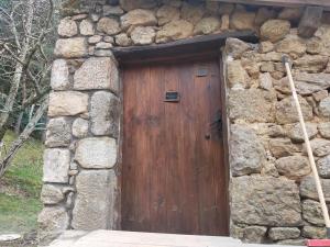 a wooden door in the side of a stone building at Gites de Fouard "La Pranièra" in Malaurier