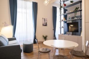 a living room with a table and a couch and a tv at EVE Home Collection - City Center in Trieste