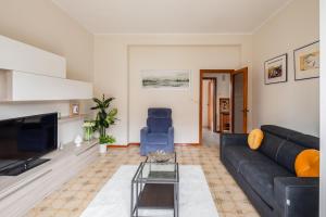 a living room with a black couch and a tv at Casa Brando in Santa Maria delle Mole