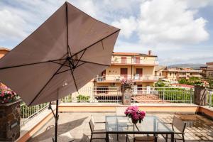 a patio with a table and chairs and an umbrella at Casa Brando in Santa Maria delle Mole