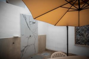 ein Badezimmer mit einem Sonnenschirm und einem Tisch und Stuhl in der Unterkunft Casa Arianna, apartment a few steps from the sea in Marina di Mancaversa + 35 Fotos