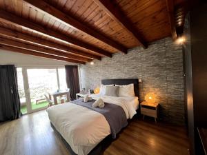 a bedroom with a large bed and a brick wall at Allure Athens Urban Suites in Athens
