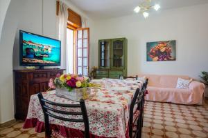 ein Wohnzimmer mit Tisch und Fernseher in der Unterkunft Casa Arianna, apartment a few steps from the sea in Marina di Mancaversa