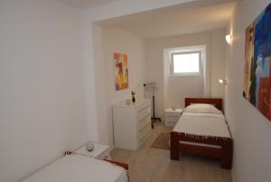 a white bedroom with two beds and a dresser at Wenn Sie in der Nähe des Strandes sein wollen, sind Sie dort in Zaostrog