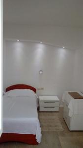 a white bedroom with a bed and a night stand at Wenn Sie in der Nähe des Strandes sein wollen, sind Sie dort in Zaostrog +14 photos