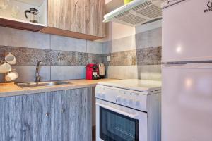a kitchen with a white stove top oven next to a sink at Allure Athens Urban Suites in Athens