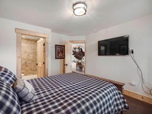 a bedroom with a bed and a tv on the wall at Cozy 2BR Condo Near Peak 8 and Town with Hot Tub Access in Breckenridge +17 photos