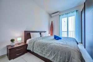 a bedroom with a bed with a blue pillow on it at Super Location, St Julians, 2 Bedroom, Paceville APT 7 by Vaganza in St Julian's