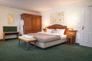 a bedroom with a large bed and a chair at Landhaus Lellichow in Lellichow
