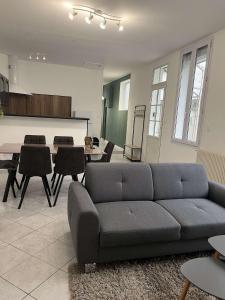 ein Wohnzimmer mit einem Sofa und einem Tisch in der Unterkunft Gîte T3 cœur de ville in Sully-sur-Loire