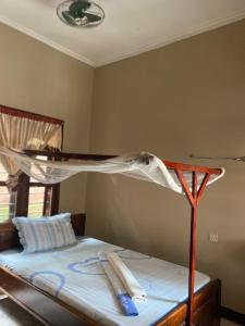キゴマにあるNzimano Hostelのベッドルーム1室(木製ベッドフレーム付きのベッド1台付)