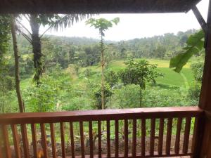 a view from the balcony of a house with a view of a field at Serenity Lodge Tetebatu Lombok in Tetebatu