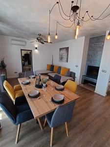 comedor y sala de estar con mesa de madera en Holiday&Suite Klanac, en Vir