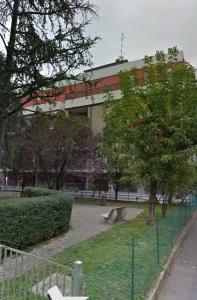 レッジョ・エミリアにあるCasa Linabelliのベンチと木が植えられた公園のある建物