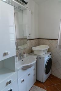 a bathroom with a sink and a washing machine at San Lorenzo House in Andria