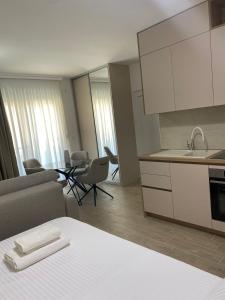 a kitchen and living room with a table and chairs at Lux apartmani Anastasija in Sutomore