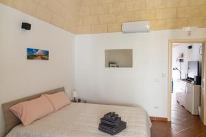 a bedroom with a bed with a pink pillow at San Lorenzo House in Andria