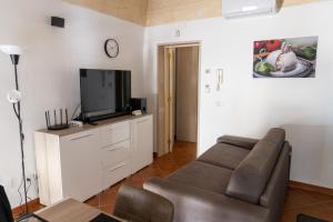 sala de estar con sofá y TV de pantalla plana en San Lorenzo House en Andria