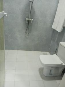 uma casa de banho com um WC branco e um chuveiro em PM Lodge and Restaurent em Matemwe