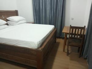 um quarto com uma cama, uma mesa e uma cadeira em PM Lodge and Restaurent em Matemwe