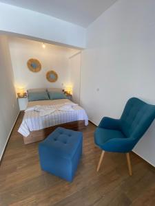 a bedroom with a bed and a blue chair at Giorgio studios II in Kokkari
