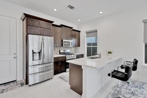 a kitchen with a refrigerator and a counter top at Centrally Located TX Medical Center - Walk to NRG! townhouse in Houston