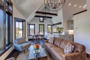 ein Wohnzimmer mit einer Couch und einem Tisch in der Unterkunft Aurum Condo - 1 BR with Mtn Views, Steps from Main St in Breckenridge
