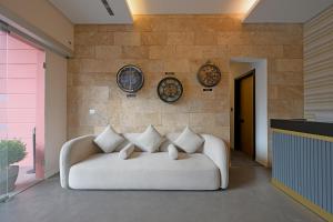 um sofá branco num quarto com pratos na parede em Comfy apart hotel em Beirute