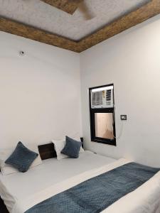 Yashoda Sadan في حاريدوار: غرفة نوم بيضاء مع سرير ومرآة