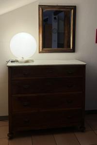 a dresser with a lamp and a mirror on it at La Soffitta di Maria in La Spezia