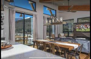 ein Esszimmer mit Tisch und Stühlen und einem großen Fenster in der Unterkunft Modern 3BR Chalet with Hot Tub and Mt Quandary Views in Blue River