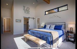 Schlafzimmer mit einem Bett mit einer Bank und einem Fenster in der Unterkunft Modern 3BR Chalet with Hot Tub and Mt Quandary Views in Blue River