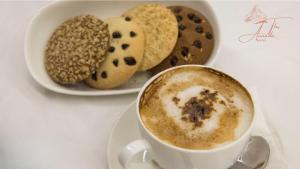 una tazza di caffè accanto a un piatto di biscotti di The Ananda Kufri, Shimla a Kūfrī