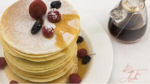 una pila di pancake con bacche su un piatto di The Ananda Kufri, Shimla a Kūfrī