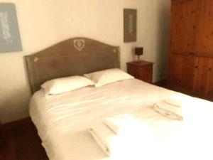 LE TILLEUL GITE SUD CHARENTE في Chalais: غرفة نوم بسرير ذو شراشف ووسائد بيضاء