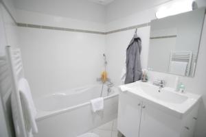 LE TILLEUL GITE SUD CHARENTE في Chalais: حمام أبيض مع حوض وحوض استحمام