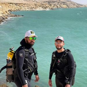 two men in wetsuits standing in the water at Mayorca scuba diving dakhla in Dakhla