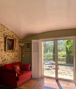 Mondragon的住宿－Domaine du Commandeur，客厅配有红色沙发和滑动玻璃门