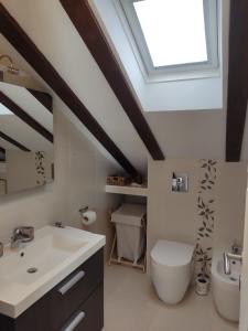 een badkamer met een wastafel, een toilet en een dakraam bij Ferienwohnung für 3 Personen 1 Kind ca 75 qm in Dubrovnik, Dalmatien Süddalmatien in Dubrovnik