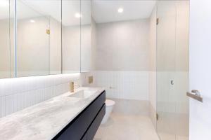 a white bathroom with a sink and a toilet at Soho Penthouse - Luxury lifestyle property in Prahran in Melbourne