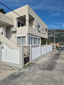 a building with a fence on the side of it at Lux apartmani Anastasija in Sutomore